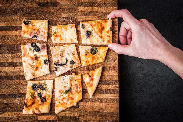 Fatias de pizza em uma tábua de madeira — Fotografia de Stock