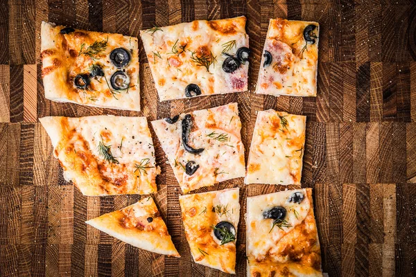 Fatias de pizza em uma tábua de madeira — Fotografia de Stock