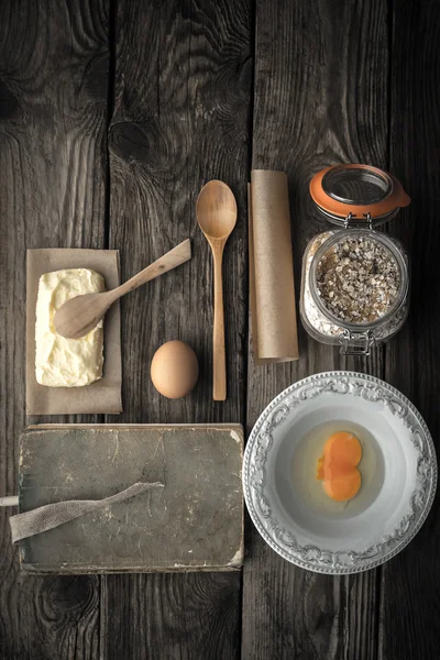 Livro de receitas, prato e ingredientes para biscoitos em uma mesa de madeira — Fotografia de Stock