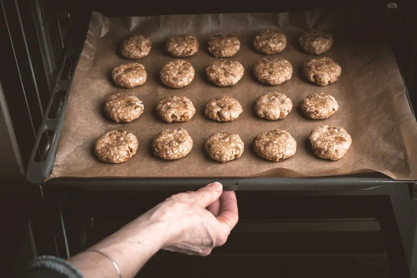 Nő pózol a cookie-k sütés a sütőben — Stock Fotó