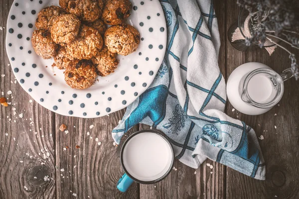 Pitcher, lavender, oatmeal cookies and a cup of milk on old boar — Stock Photo, Image