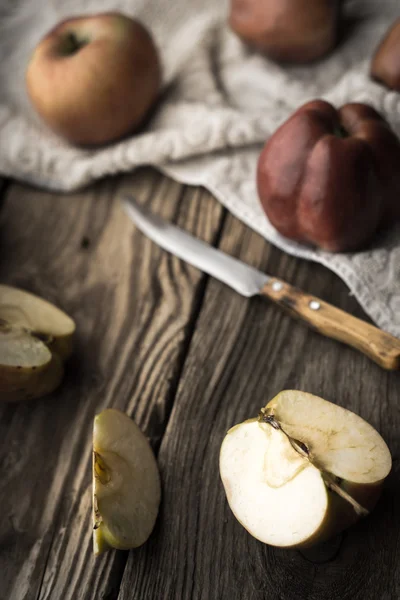 Röda äpplen och apple halvor på ett träbord — Stockfoto