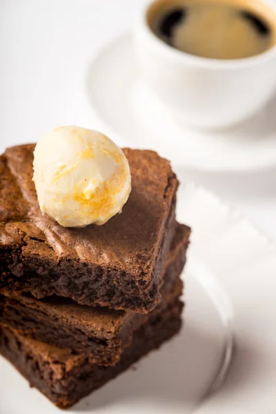 Brownie se zmrzlinou a šálek kávy na stole — Stock fotografie