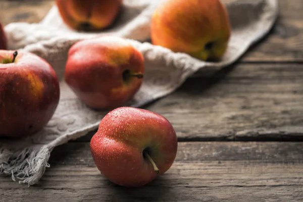 Rote Äpfel und Handtuch auf den alten Brettern — Stockfoto