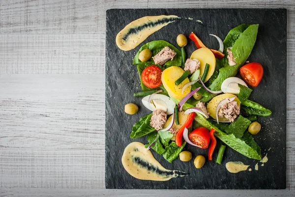 Salată de nicoise pe piatra neagră de pe masă — Fotografie, imagine de stoc