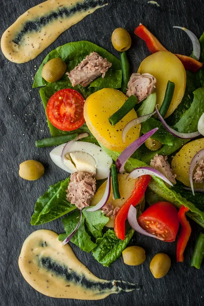 Nicoise salad with sauce on the black stone  vertical — Stock Photo, Image