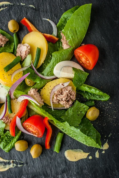 Ensalada Nicoise en la piedra negra vertical —  Fotos de Stock