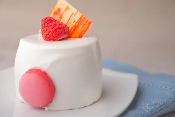 Kue putih dengan raspberry di serbet biru — Stok Foto