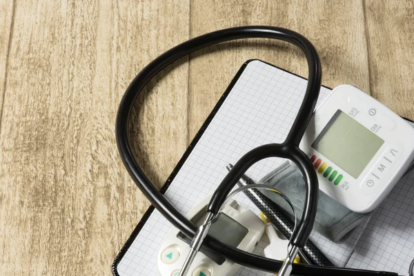 Stethoskop auf Holztisch mit Kopie der Blutdruckmessung — Stockfoto