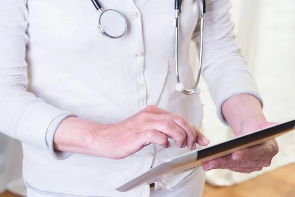 Médico fêmea está segurando um comprimido na mão — Fotografia de Stock