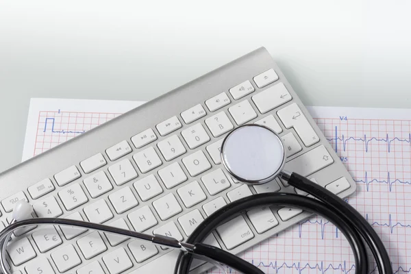 Estetoscópio, ecg e teclado na mesa do médico — Fotografia de Stock