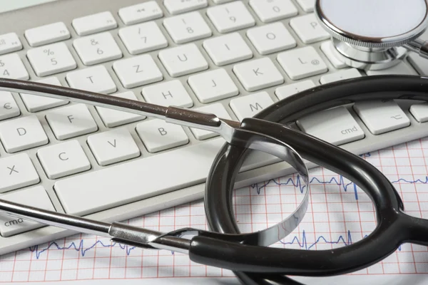 Nahaufnahme von Stethoskop, EKG und Tastatur auf dem Arzttisch — Stockfoto