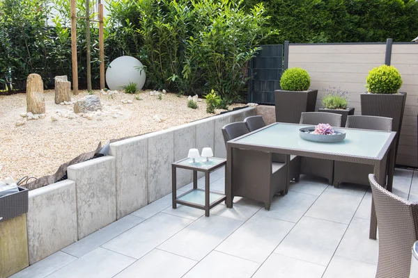 Nouveau jardin en pierre aménagé avec terrasse et table et chaises — Photo