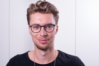 Akıllı genç profesyonel kameraya gülümseyen