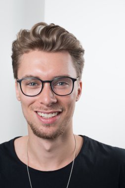 Akıllı genç profesyonel kameraya gülümseyen