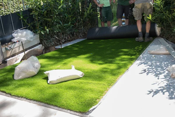 Jardineros profesionales están desplegando césped artificial —  Fotos de Stock