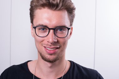 Akıllı genç profesyonel kameraya gülümseyen