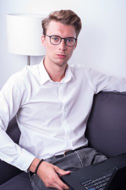 evde koltukta çalışan genç iş adamı