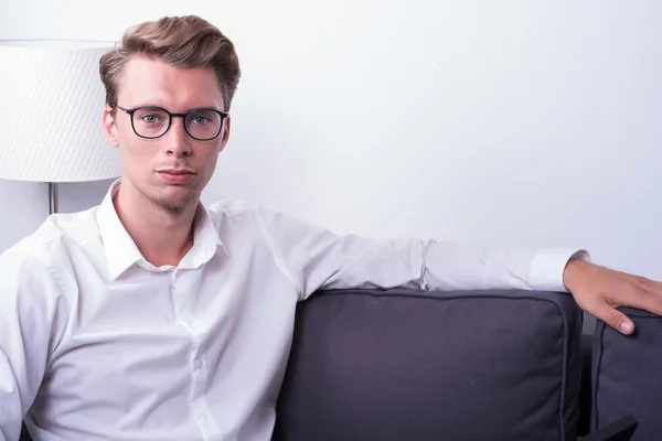 Young handsome man relaxing at home on the couch — Stock Photo, Image