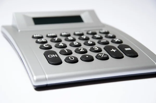 Calculator lying on white underground — Stock Photo, Image