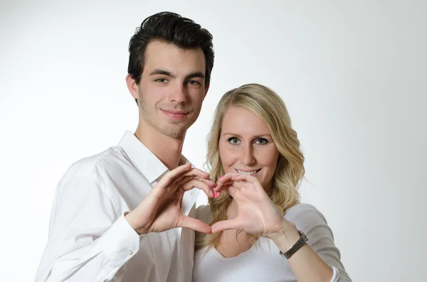 对年轻的夫妇正在形成心用他们的双手 — 图库照片
