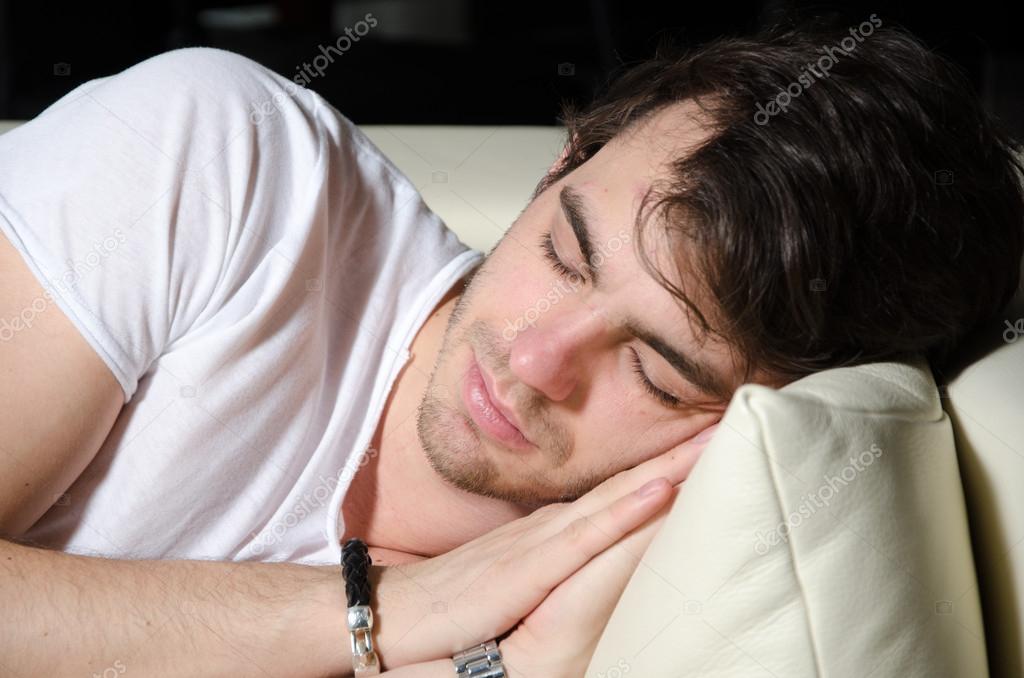 Young man sleeps on couch