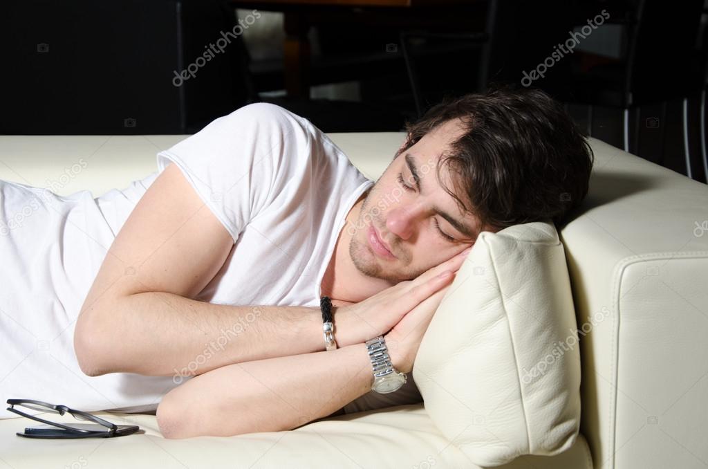 Young man sleeps on couch