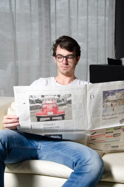 Young man reads newspaper — Stock Photo, Image
