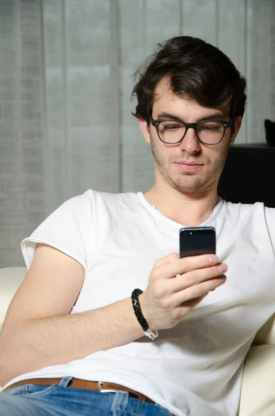 Young man reads on his smartphone — Stock Photo, Image