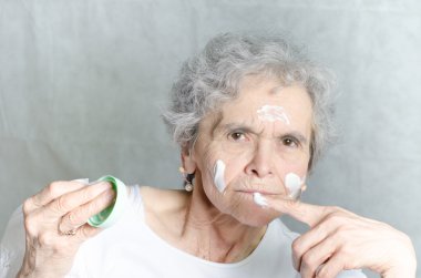 Yaşlı kadın ile onun yüzüne kozmetik