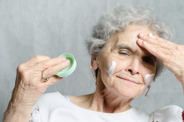 Yaşlı kadın ile onun yüzüne kozmetik