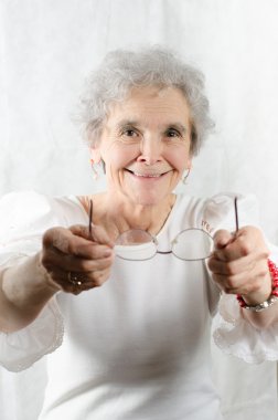 Yaşlı kadın gözlüklerini sunan