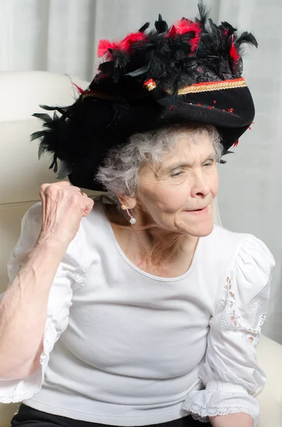 Stará žena s Karneval klobouk hurá pro karneval — Stock fotografie