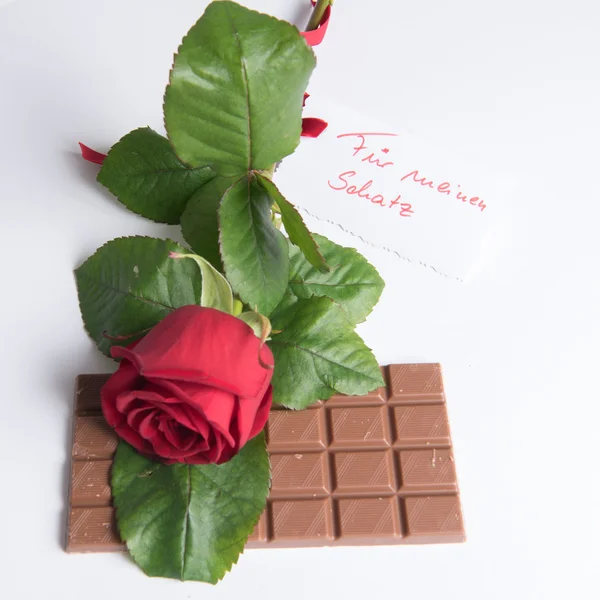 Rosa y chocolate con tarjeta en alemán Fuer meinen Schatz — Foto de Stock