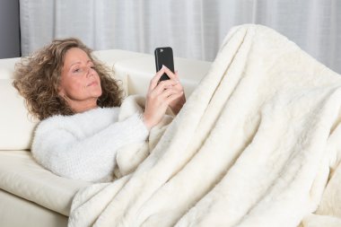 Akıllı telefondan mesaj okuyan kadın