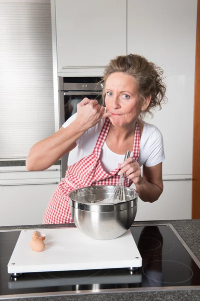 Žena v kuchyni ochutnávka — Stock fotografie