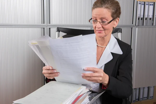 Chef feminino no escritório com um monte de papéis — Fotografia de Stock