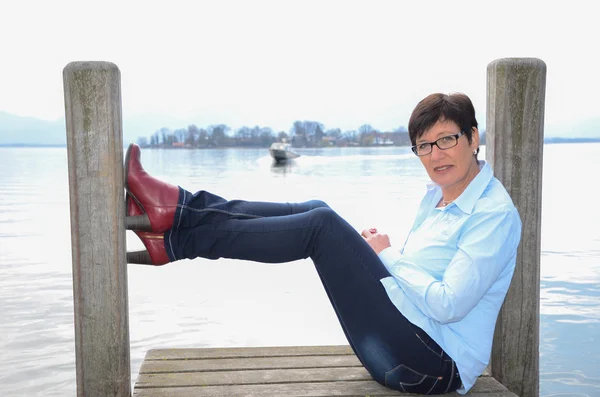 Mujer sentada en el lago Chiemsee — Foto de Stock