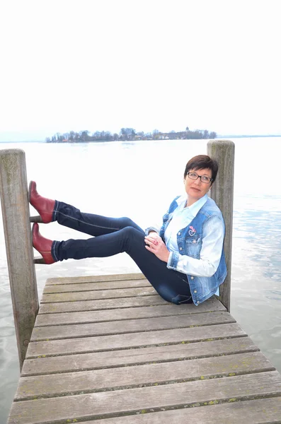 Mujer sentada en el lago Chiemsee — Foto de Stock