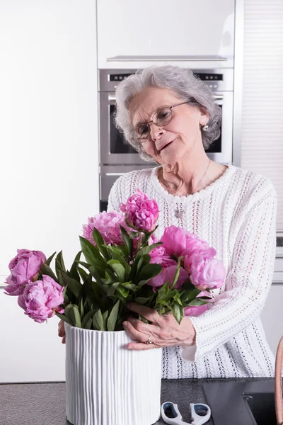 Ενεργό συνταξιούχος θηλυκό ετοιμάζει λουλούδια για το βάζο — Φωτογραφία Αρχείου