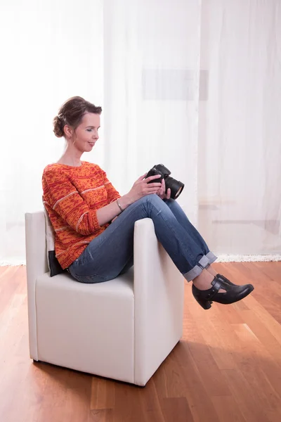 Fotograf kobieta siedzi w fotelu — Zdjęcie stockowe