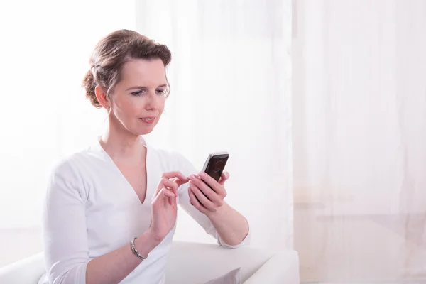 Strong woman is reading message on smartphone — Stock Photo, Image