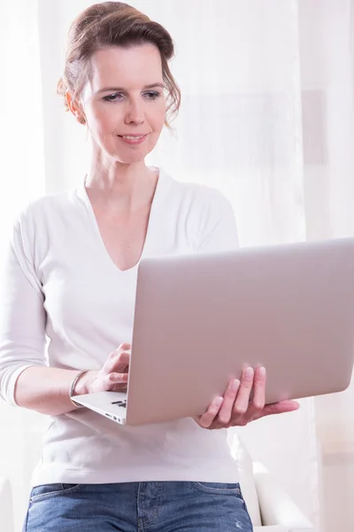 Atrakcyjna kobieta pracuje z komputerem na jej ręce — Zdjęcie stockowe