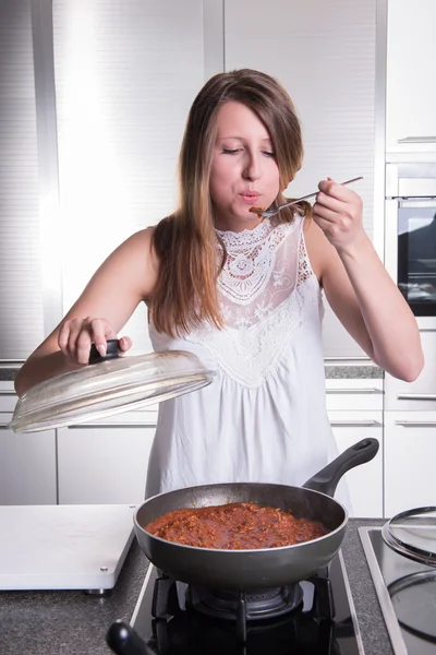 Atractivo estudiante de cocina salsa boloñesa en la cocina — Foto de Stock