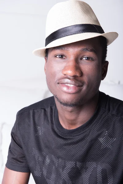 African man with hat sitting on couch — Stock Photo, Image