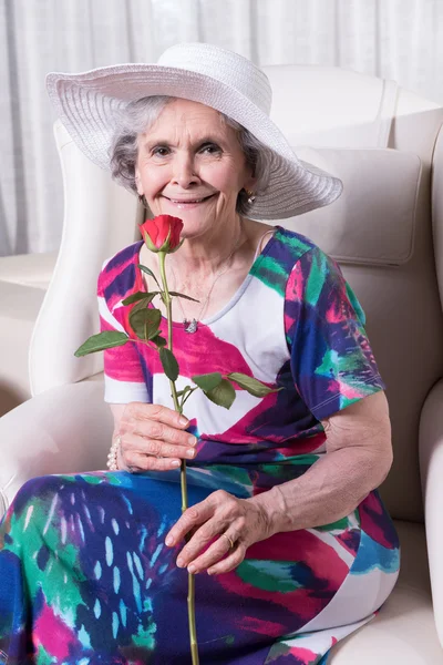 Active female senior with rose in her hand — Zdjęcie stockowe