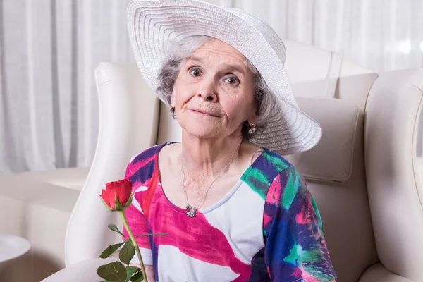 Active female senior with rose in her hand — Stock fotografie