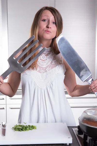 Attractive young woman with big fork and knife — Stock fotografie