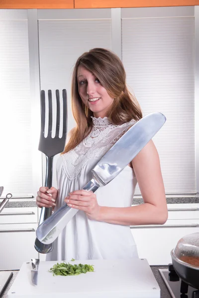 Attractive young woman with big fork and knife — Stock fotografie