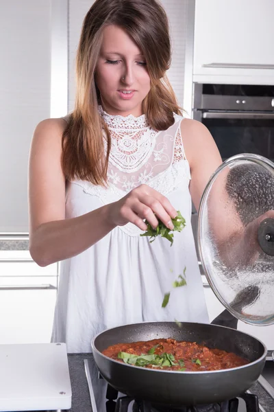 Young woman cooking spaghetti bolognese — Stok fotoğraf